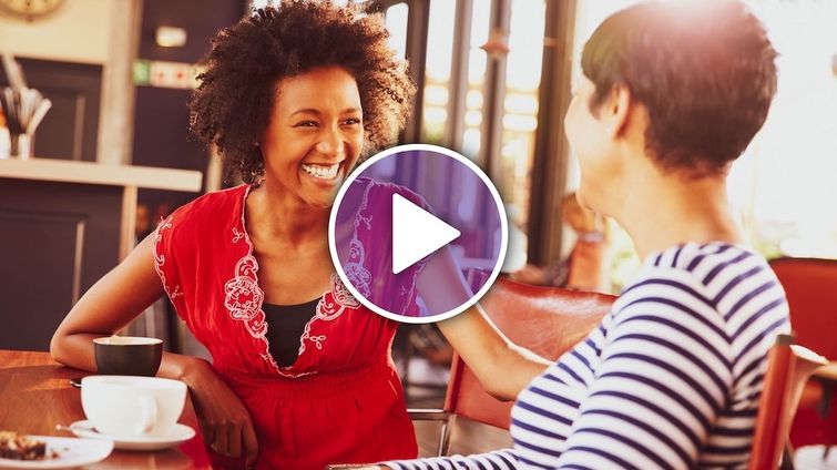 Two female small business owners sitting at a coffee shop laughing showing power of referrals