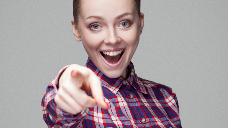 woman smiling and pointing outward