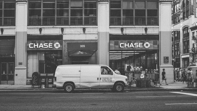 white van in front of chase bank on busy city street