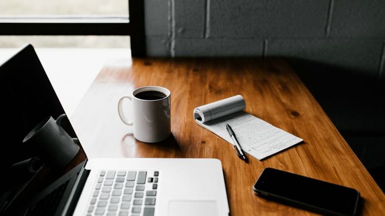 laptop open on a desk showing remote work