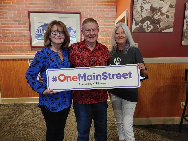 natalie deleo, tom harris, and sue brooke with one main street sign