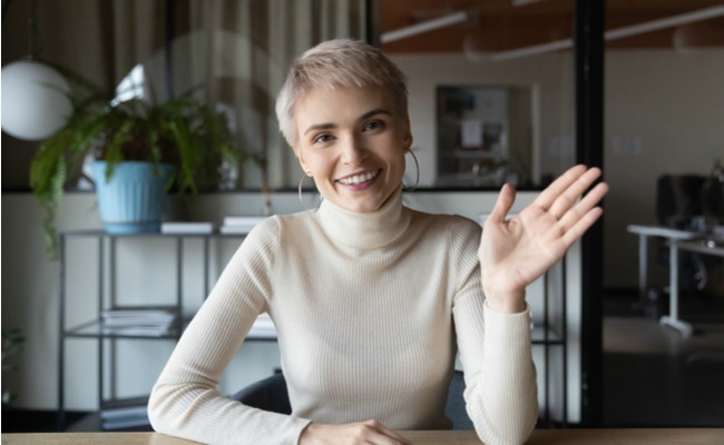 shorthaired woman waving at camera while hosting virtual networking events