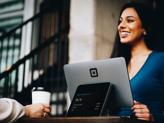 small business owner selling coffee to customer