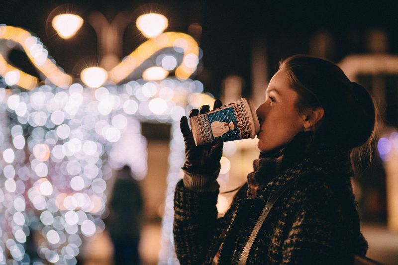 woman drinking coffee at holiday stroll