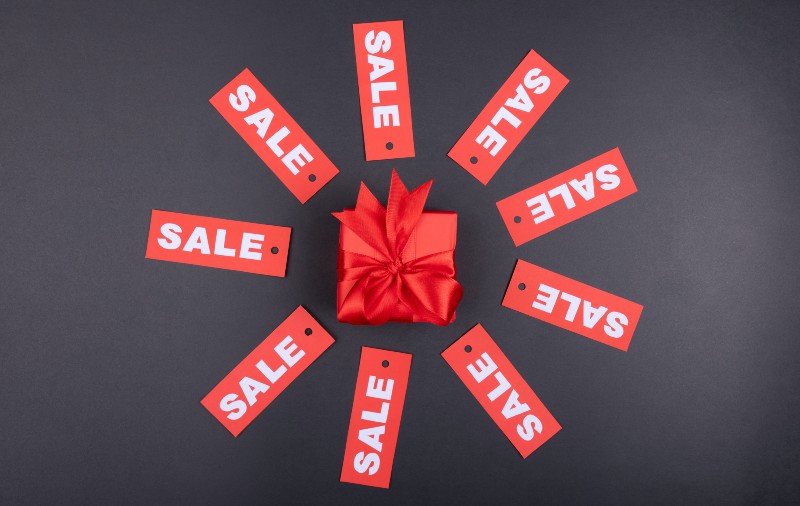 sale signs around red gift