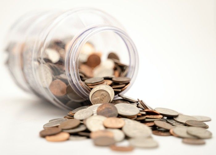 spilled coins coming out of jar 
