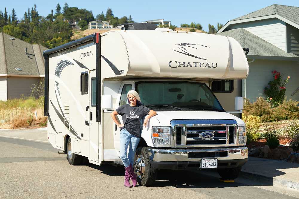 Alignable on the road Sue Brooke standing in front of RV