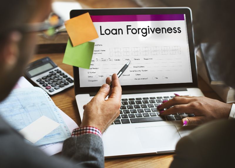 two business owners filling out ppp loan forgiveness under $150k application form 3508s