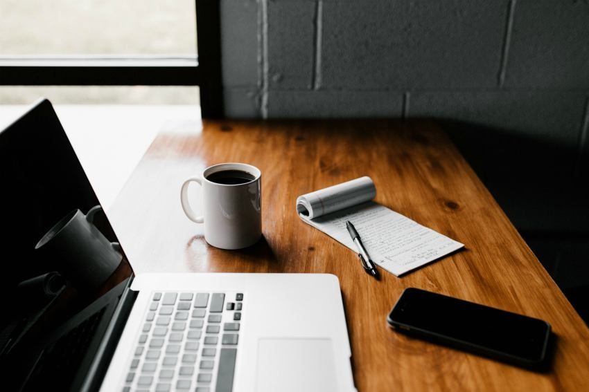 macbook on table with coffee remote work for small businesses coronavirus